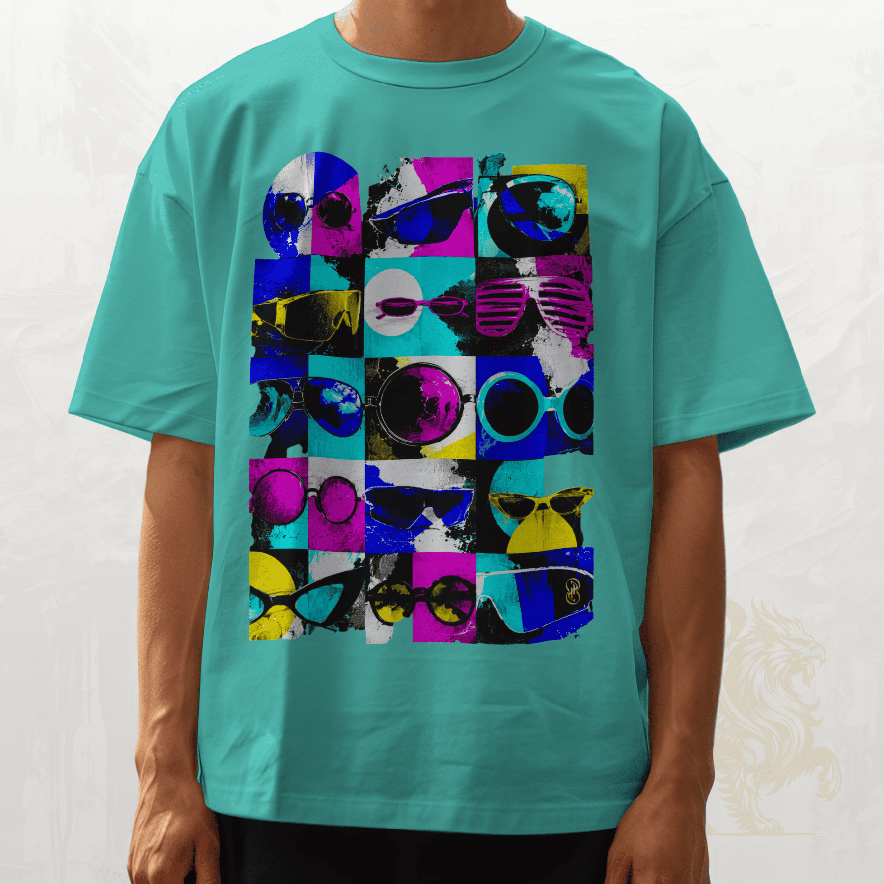 A person wearing a turquoise short-sleeve crewneck t-shirt with a colourful pop-art graphic of sunglasses in a grid pattern on the front.