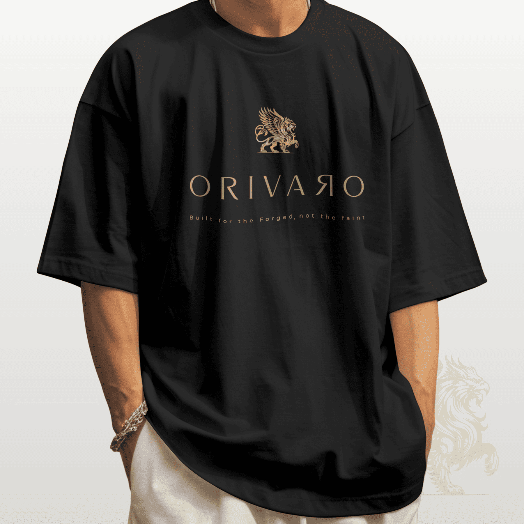 A person wearing an oversized black T-shirt with a metallic gold Griffin logo and the brand name 'ORIVARO' printed on the chest, paired with off-white pants against a light grey background.
