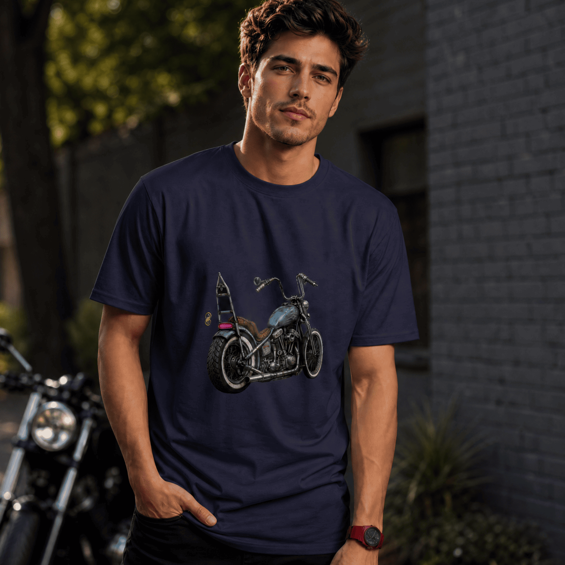 Man wearing a navy blue t-shirt with a motorcycle graphic, standing next to a motorcycle.