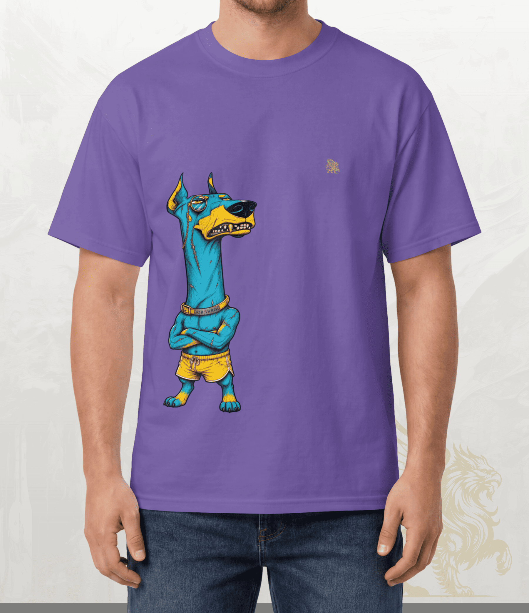 A man wearing a purple short-sleeve t-shirt with a cartoon graphic of an Egyptian pharaoh dog wearing yellow shorts. The background is a light textured wall.
