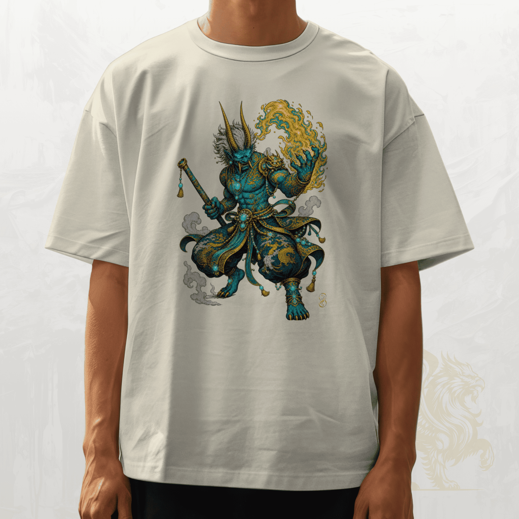 A person wearing an oversized off-white t-shirt with a detailed graphic of a blue and gold warrior character on the front, set against a light grey background.
