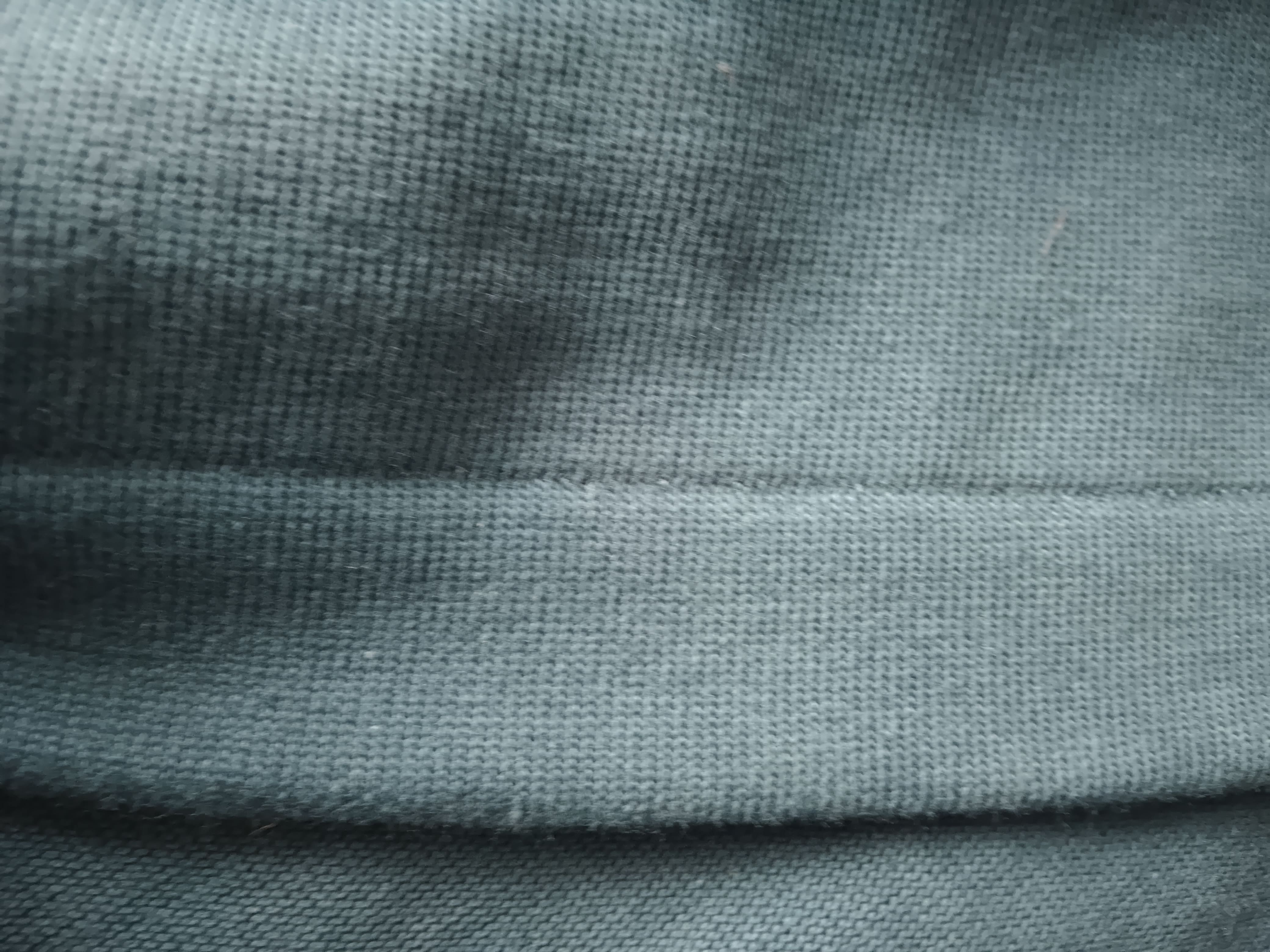 Close-up of textured gray fabric with a visible seam.