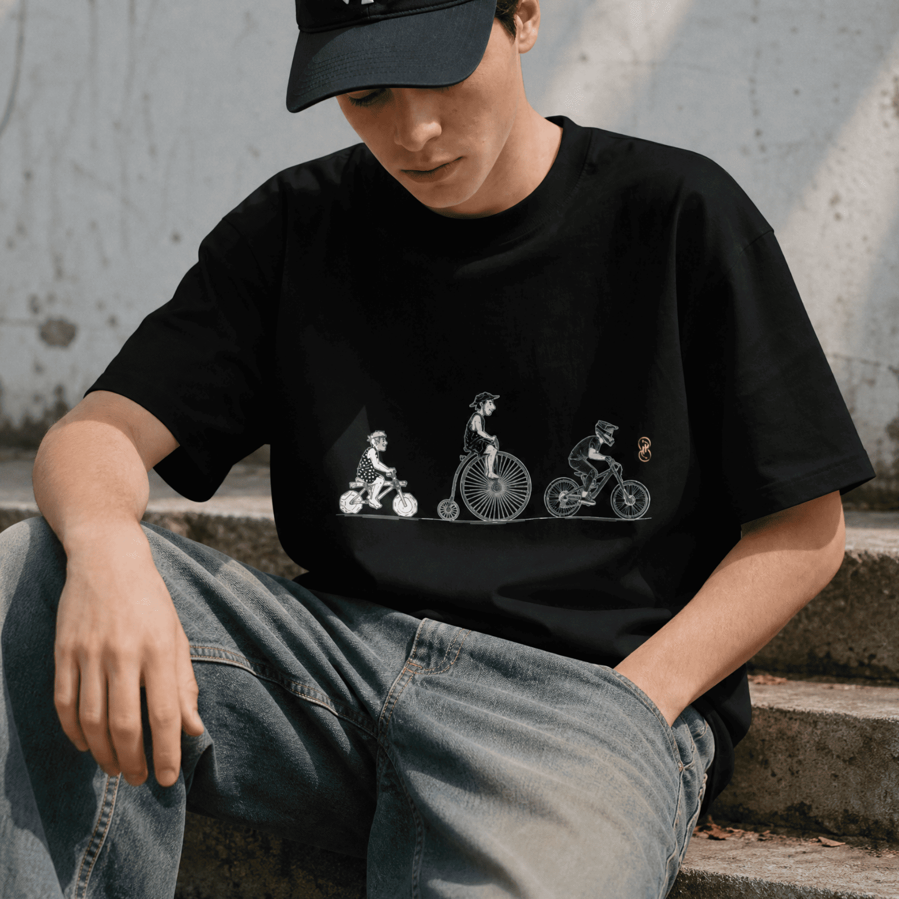 Person wearing a black t-shirt with a graphic design sitting on concrete steps.