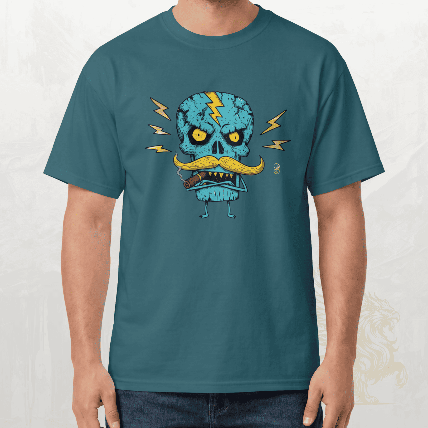 A man wearing a teal blue t-shirt with a cartoon graphic of a skull wearing a yellow mustache and lightning bolts, paired with dark blue jeans.