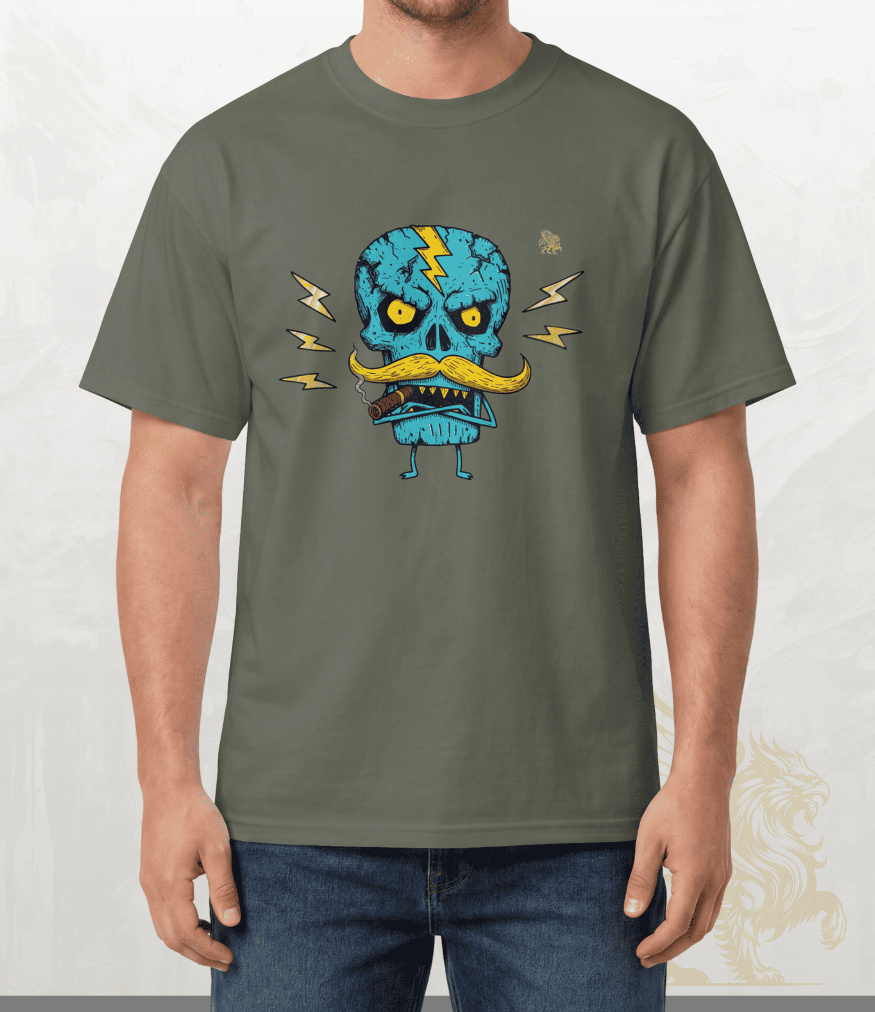 A man wearing an olive green t-shirt with a cartoon graphic of a blue skull character with a yellow mustache and lightning bolts, paired with blue jeans.