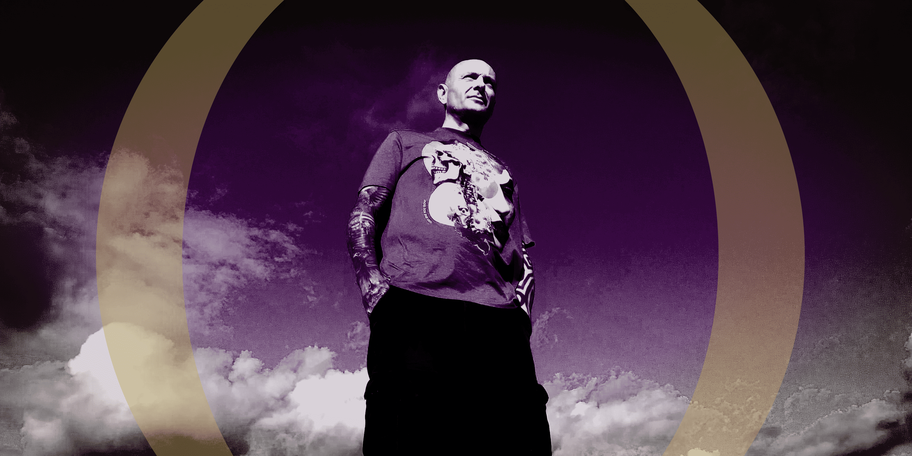 Person wearing a graphic t-shirt with a purple sky and clouds in the background