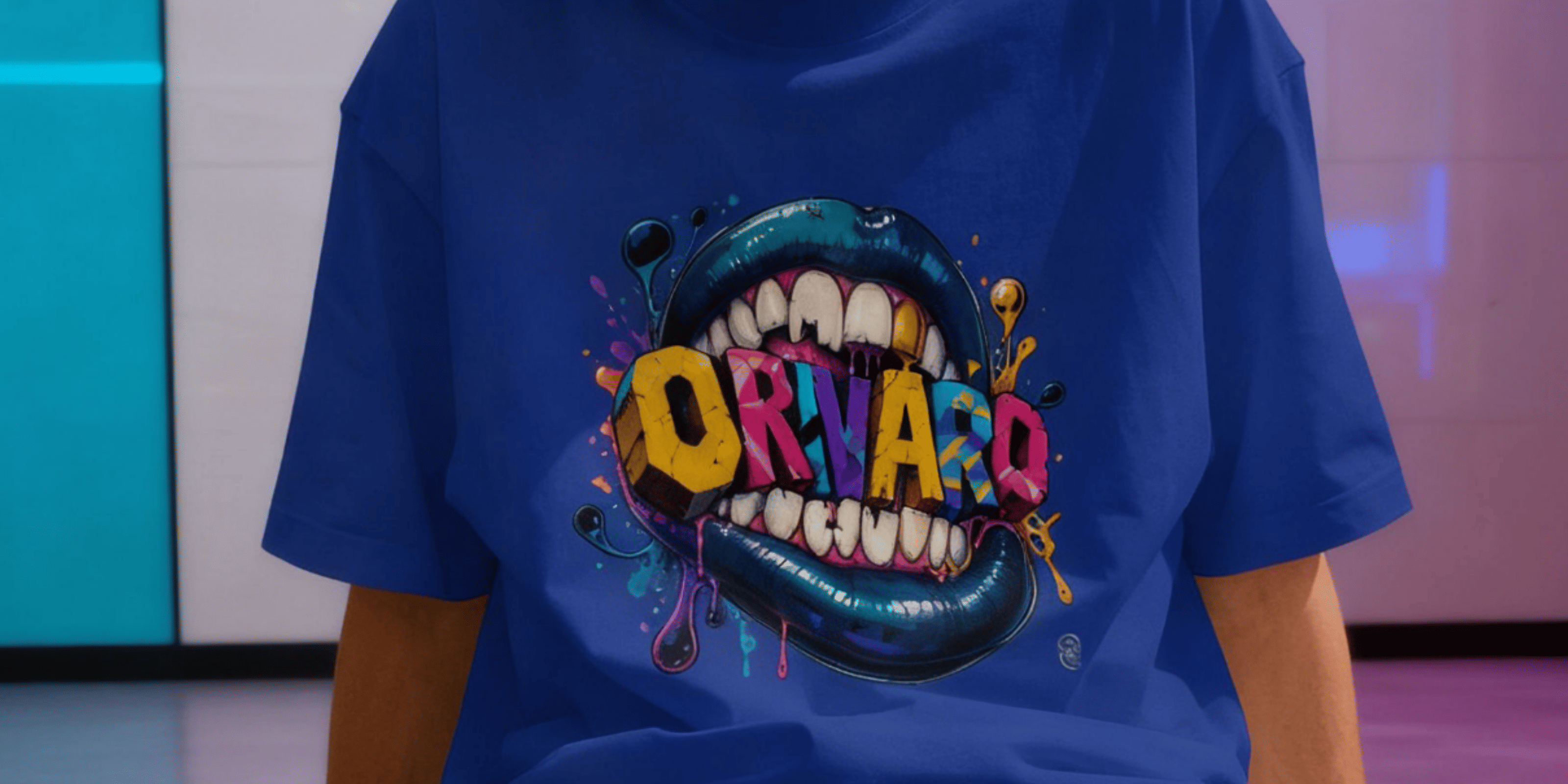 A person wearing a royal blue t-shirt with a colourful graphic of a mouth with teeth and the word 'ORNARD' in dripping letters.